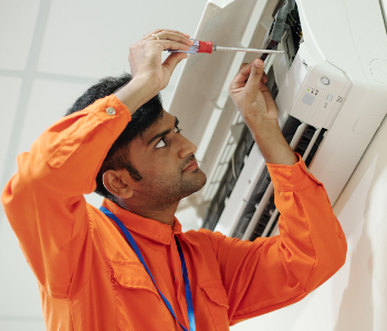 indian man setting up air conditioner RJ9VBA6