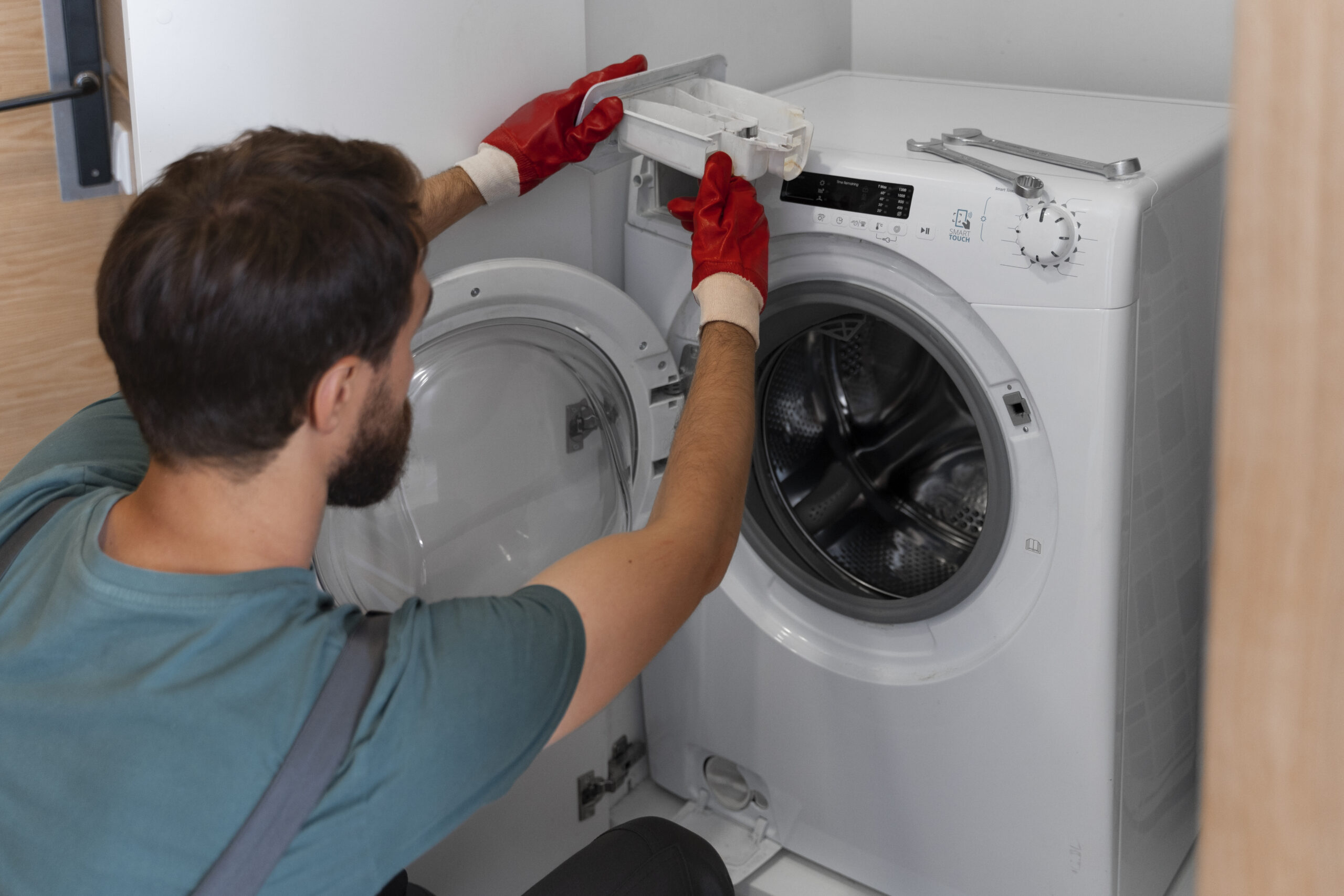 a technician opening washing machine to repair